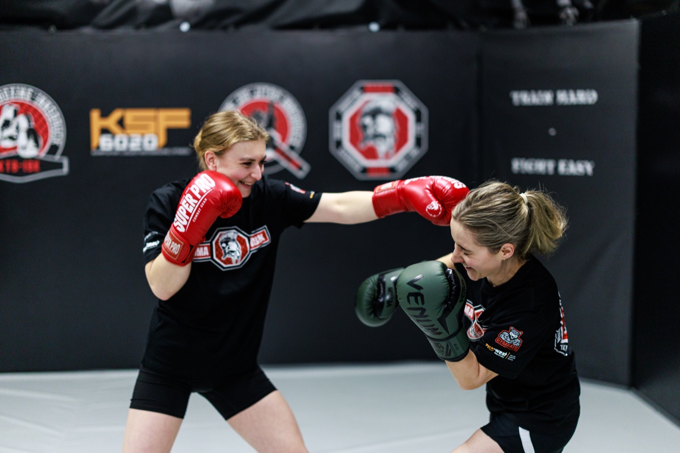 Erwachsene Athletin bereitet sich freundlich mit Boxhandschuhen auf das Training vor