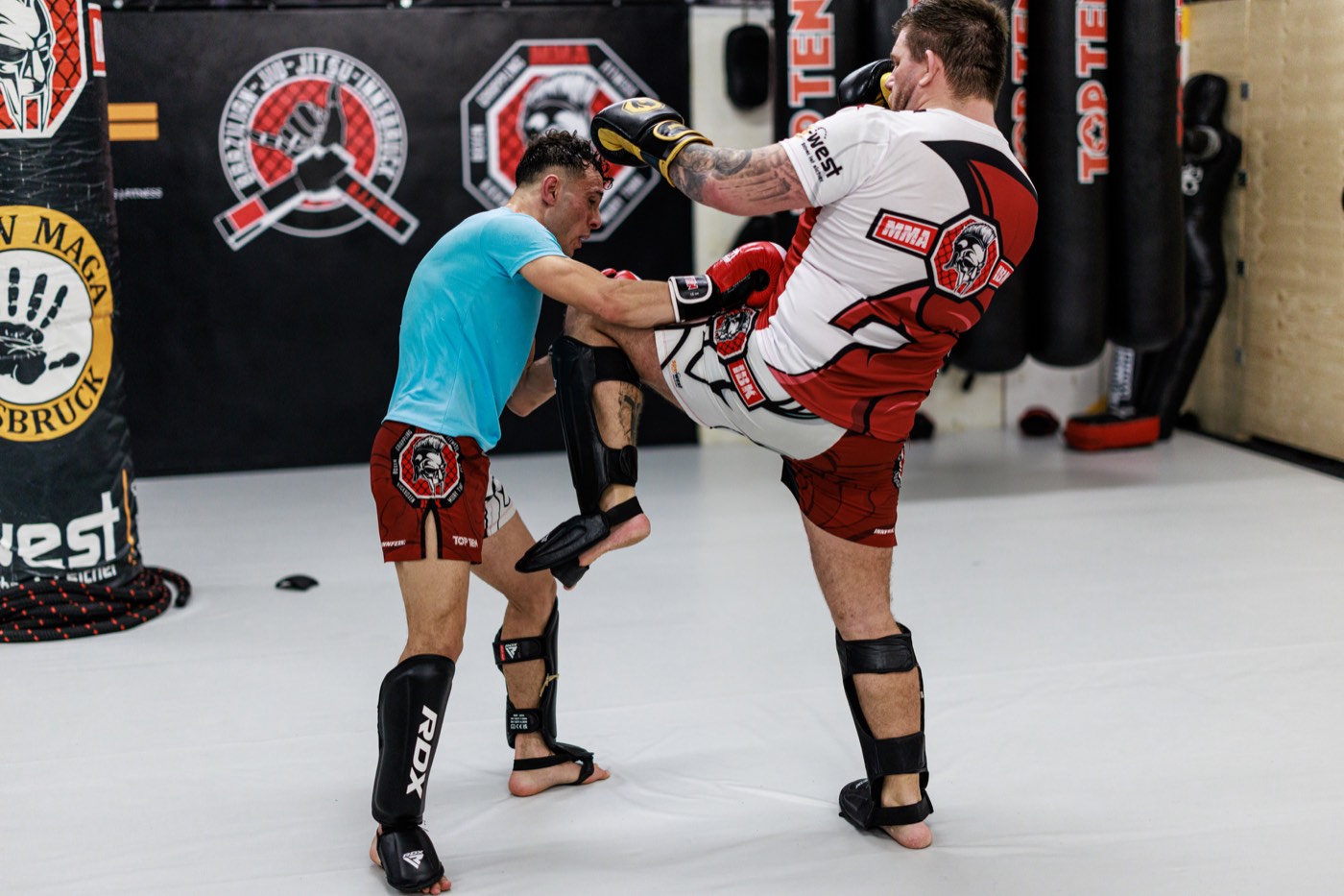Erwachsene beim Kick Thai Boxen mit Kick und Pratzenarbeit