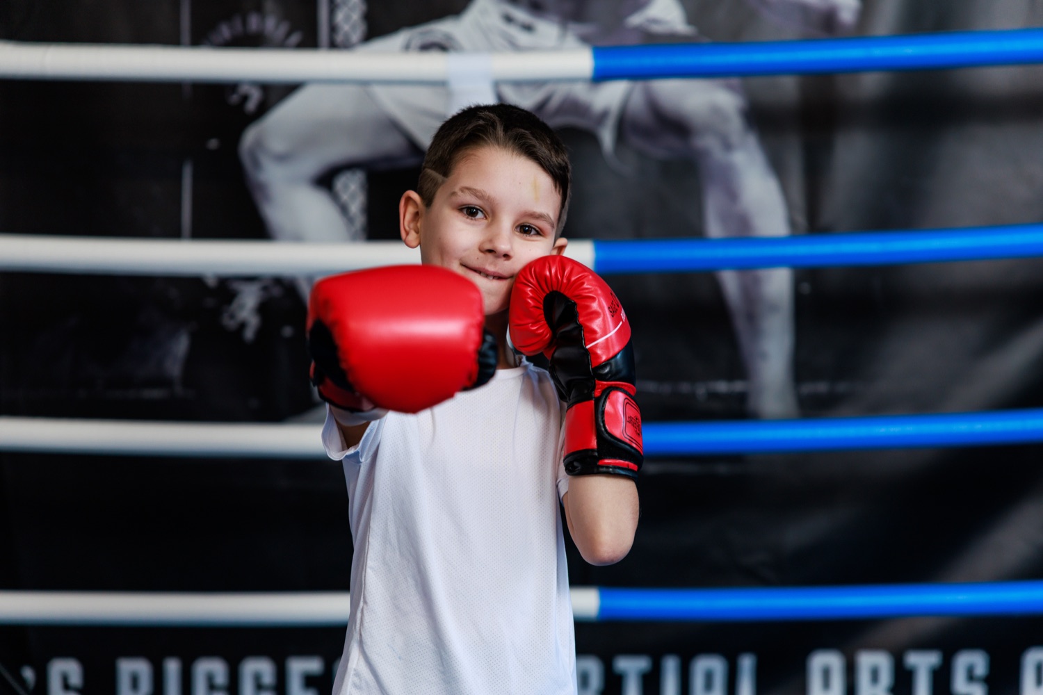 Kind mit roten Boxhandschuhen beim Kick Thai Boxen
