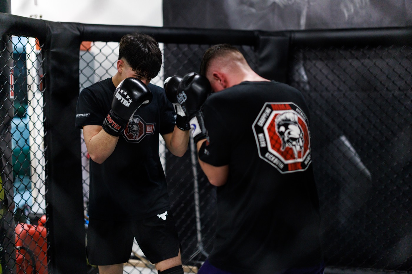 Erwachsene beim Kick Thai Boxen Sparring am Cage