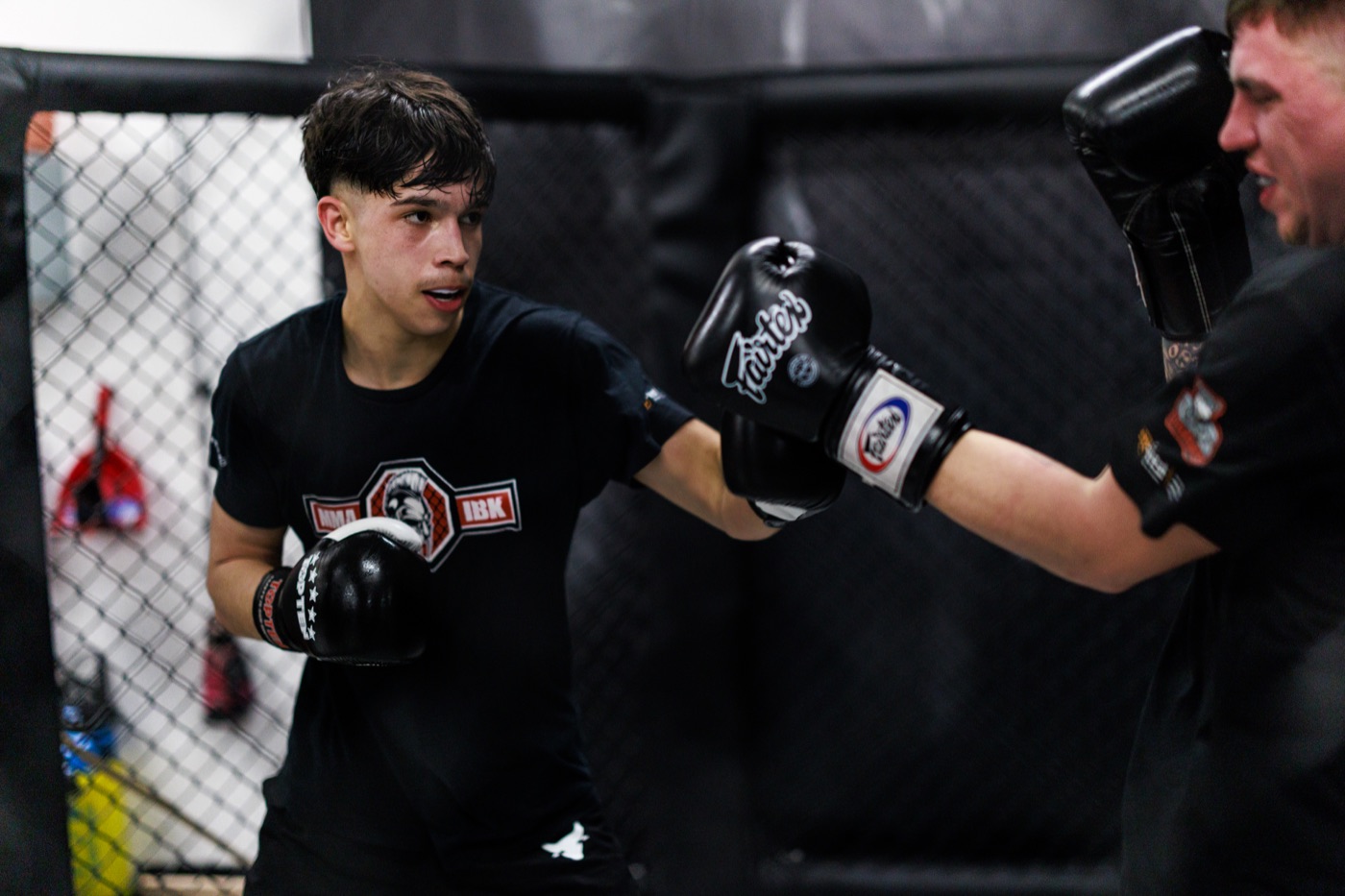Erwachsene beim MMA Training mit Cage-Arbeit