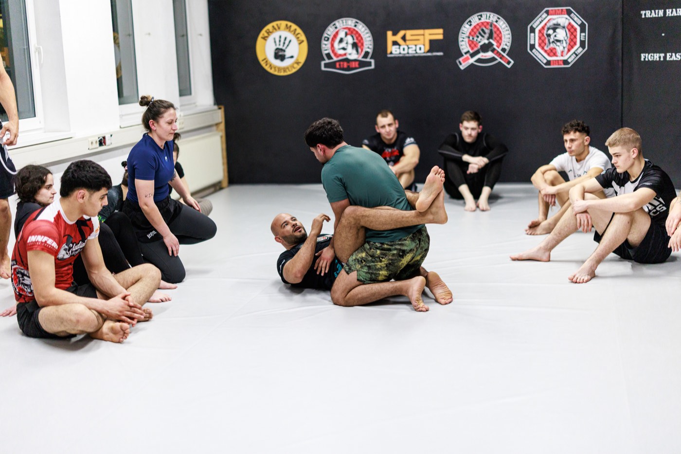 Erwachsene Trainingsgruppe beim gemeinsamen Techniktraining auf der Matte